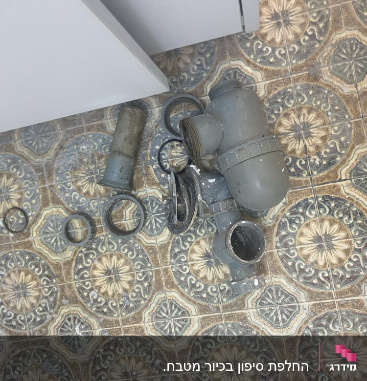 חלקי צנרת פלסטיק על רצפה מעוטרת